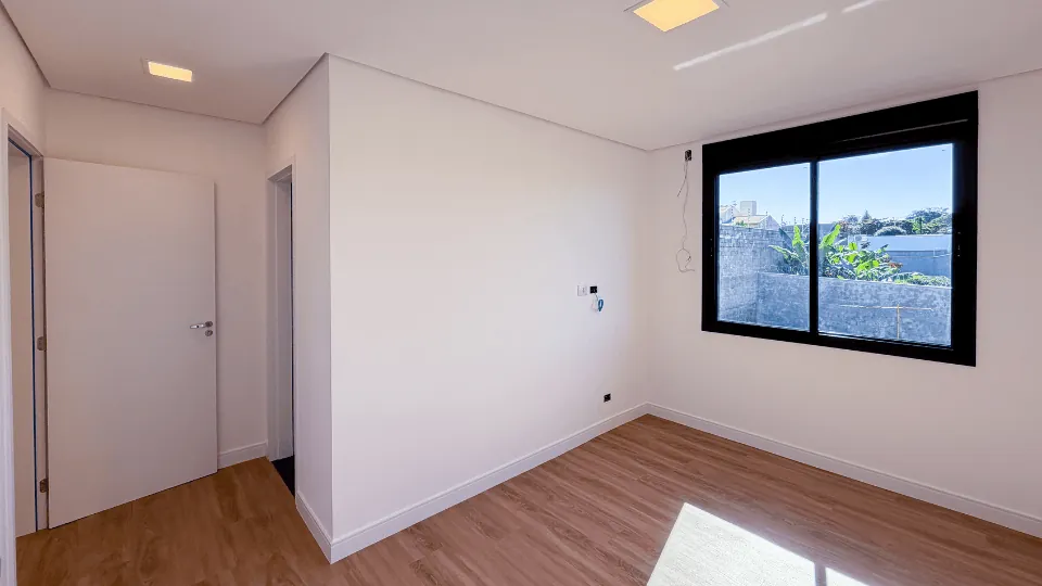 Suíte da Casa 01 com piso vinílico e janela ampla
